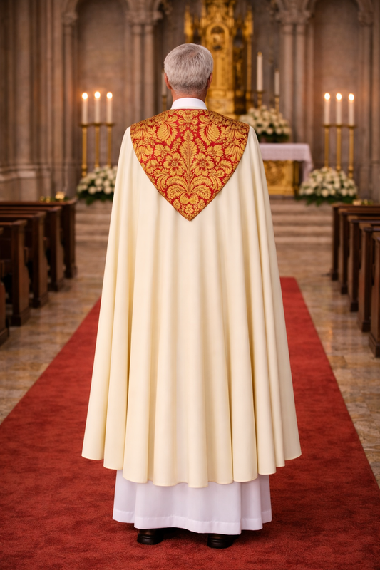 Priest in a white robe with a red and gold cope embroidered back in a church setting