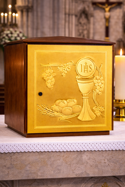 Single door tabernacle with chiseled image of a chalice, grapes, and ears of wheat sourrounded by a wood casing. Made in Italy and sold by The Clergy Store