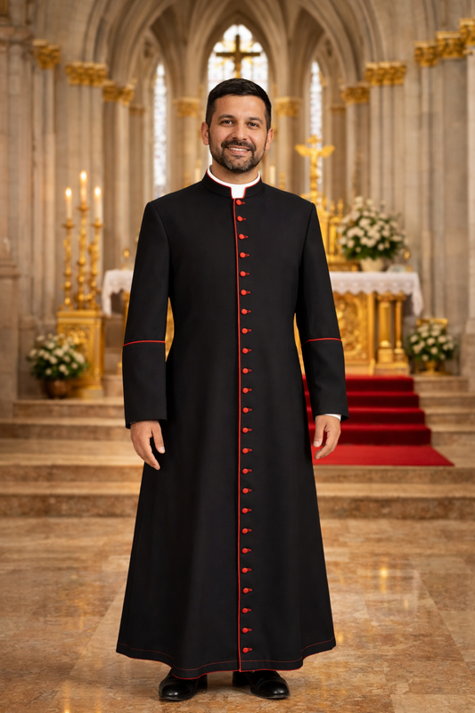 Priest in a black cassock with red buttons and contrast standing in a cathedral.