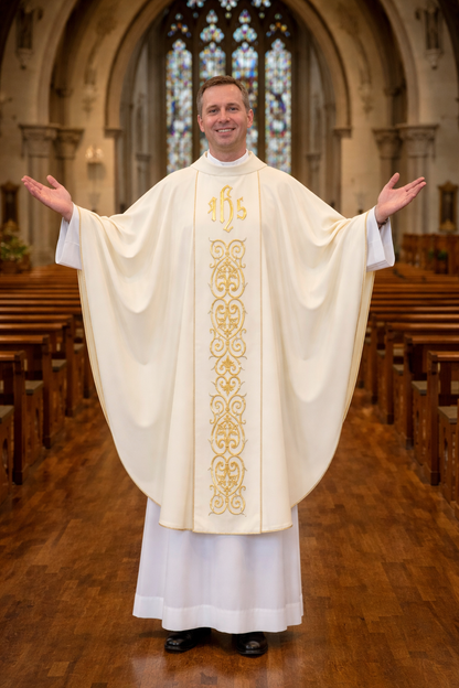 Priest in a white robe with gold embroidery standing in a church nave with stained glass windows.