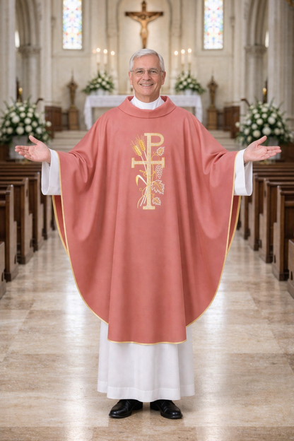 Priest in a church wearing a pink chasuble with a symbol, standing in an aisle.