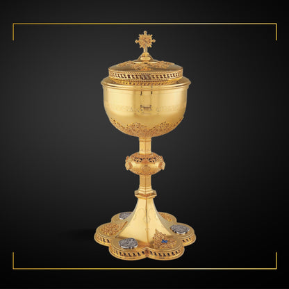 Ciborium neo-gothic style with medallions depicting the Life of Christ and cup inscription: “ECCE AGNUS DEI QUI TOLLIT PECCATA MUNDI” , 12 1/4” Ht. , 250 Hosts Sold by The Clergy Store