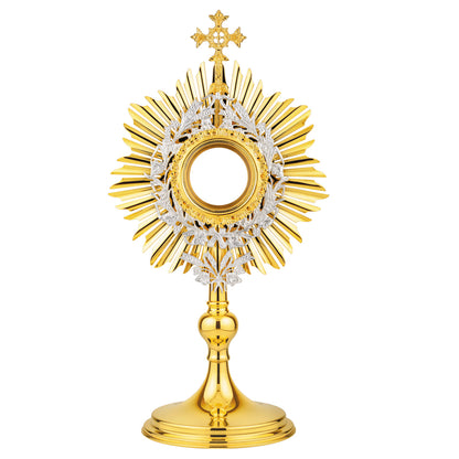 Brass monstrance in traditional style, 24-karat gold plated with silver-plated accents. The sunburst is topped with a decorative cross. Gold-rimmed luna case is surrounded by a silver-plated wreath of wheat and grapevine leaves. An ornament shaped as a bouquet of wheat is attached to the bottom of the glory. The design of this monstrance makes it suitable for use in both historical and modern interiors.