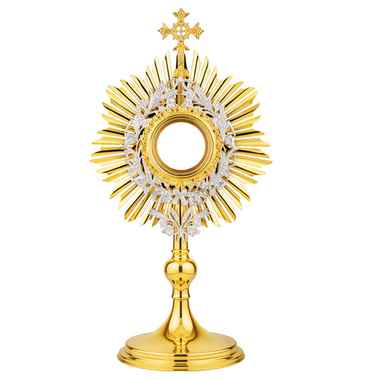 Brass monstrance in traditional style, 24-karat gold plated with silver-plated accents. The sunburst is topped with a decorative cross. Gold-rimmed luna case is surrounded by a silver-plated wreath of wheat and grapevine leaves. An ornament shaped as a bouquet of wheat is attached to the bottom of the glory. The design of this monstrance makes it suitable for use in both historical and modern interiors.