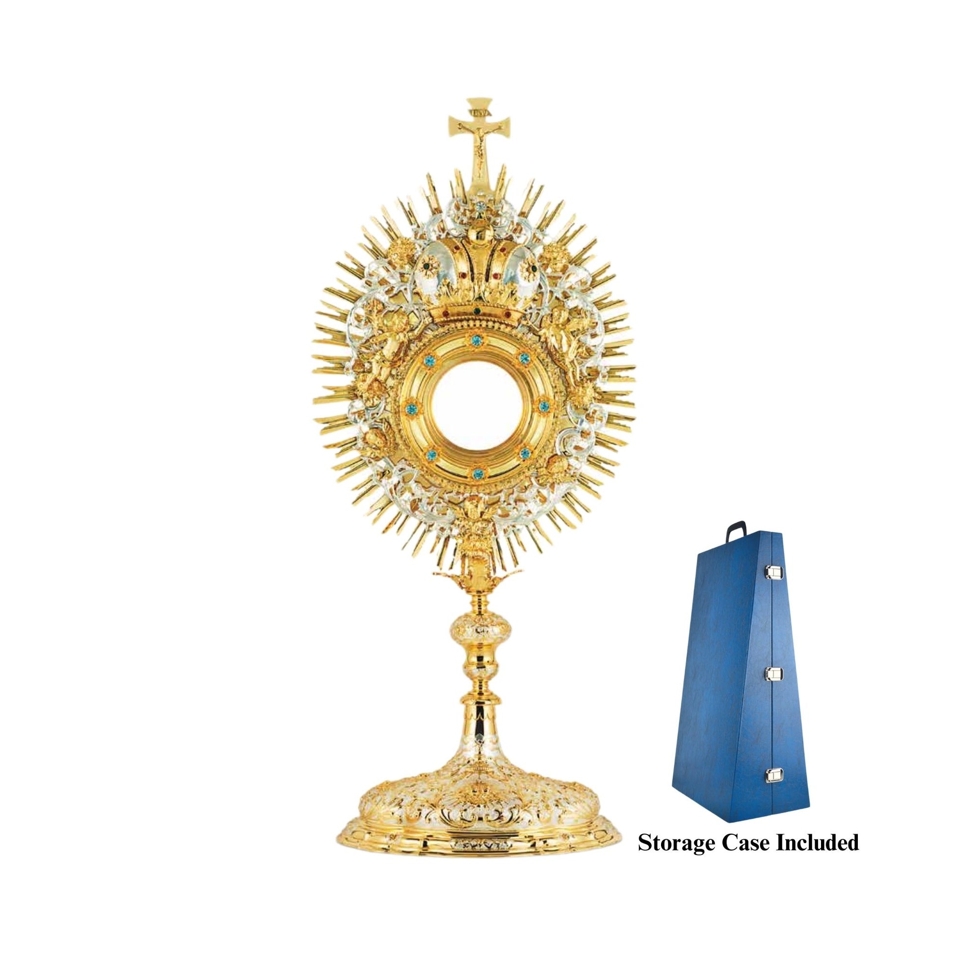 Baroque monstrance made of brass, 24-karat gold-plated with silver-plated accents. The luna case is encrusted with synthetic blue stones and surrounded by a decorative wreath with a crown and images of angels. The glory is sunburst-shaped and topped with a cross. The node and the base are adorned with rich ornamental patterns in two tones. 