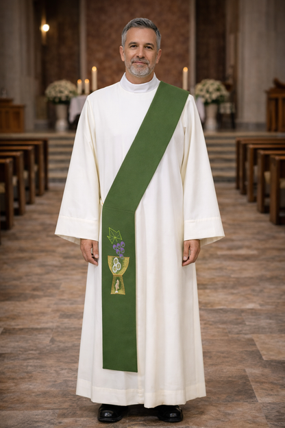 Deacon in white alb with green stole with chalice and grapes design standing in a church.