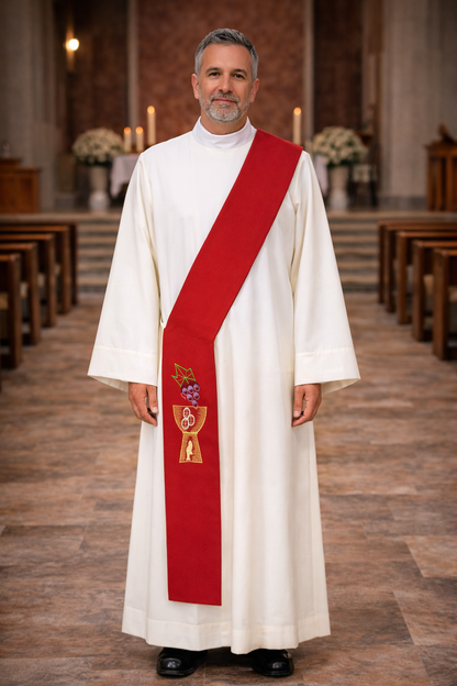 Deacon in white alb with red stole with chalice and grapes design standing in a church.