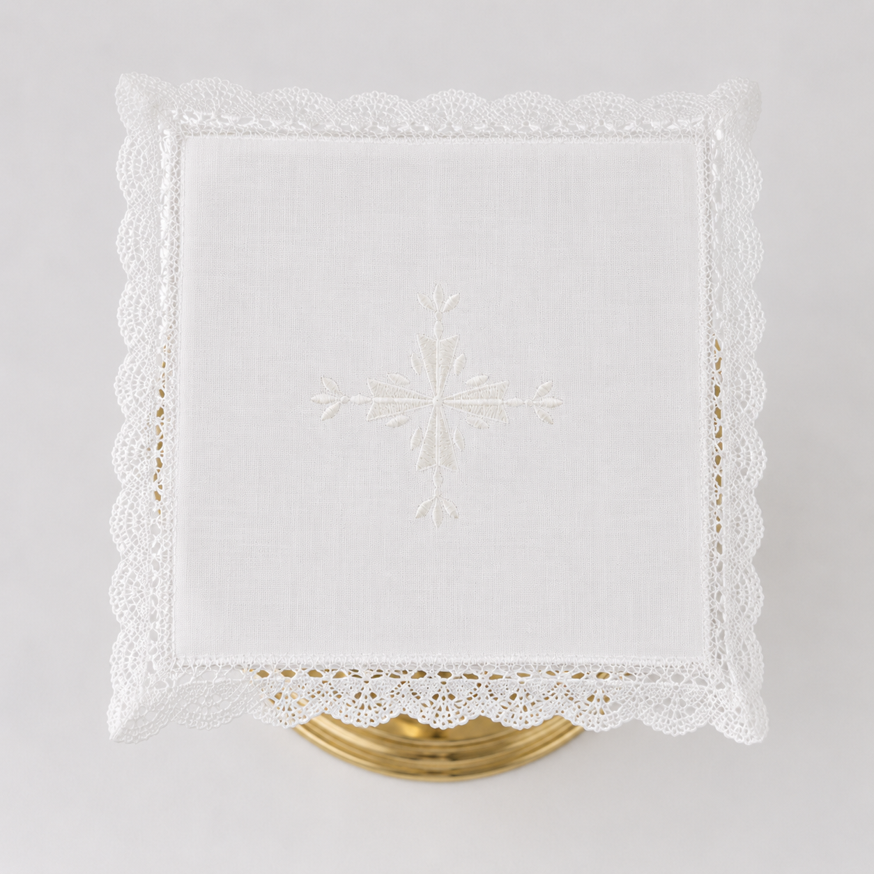 Square Italian linen chalice pall with a centered embroidered cross and crisp lace border.