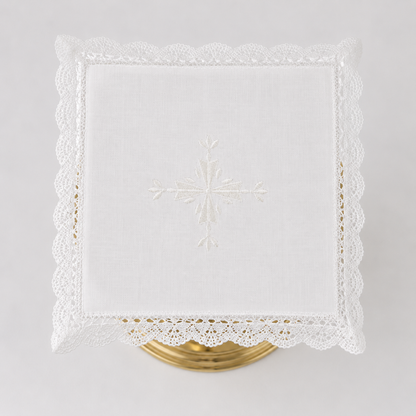 Square Italian linen chalice pall with a centered embroidered cross and crisp lace border.