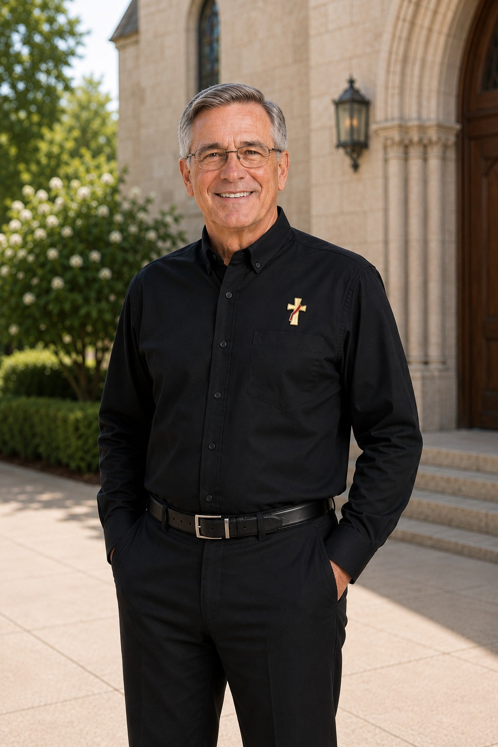 Deacon wearing a long sleeve black shirt with an embroidered symbol of a deacons cross on his left chest.
