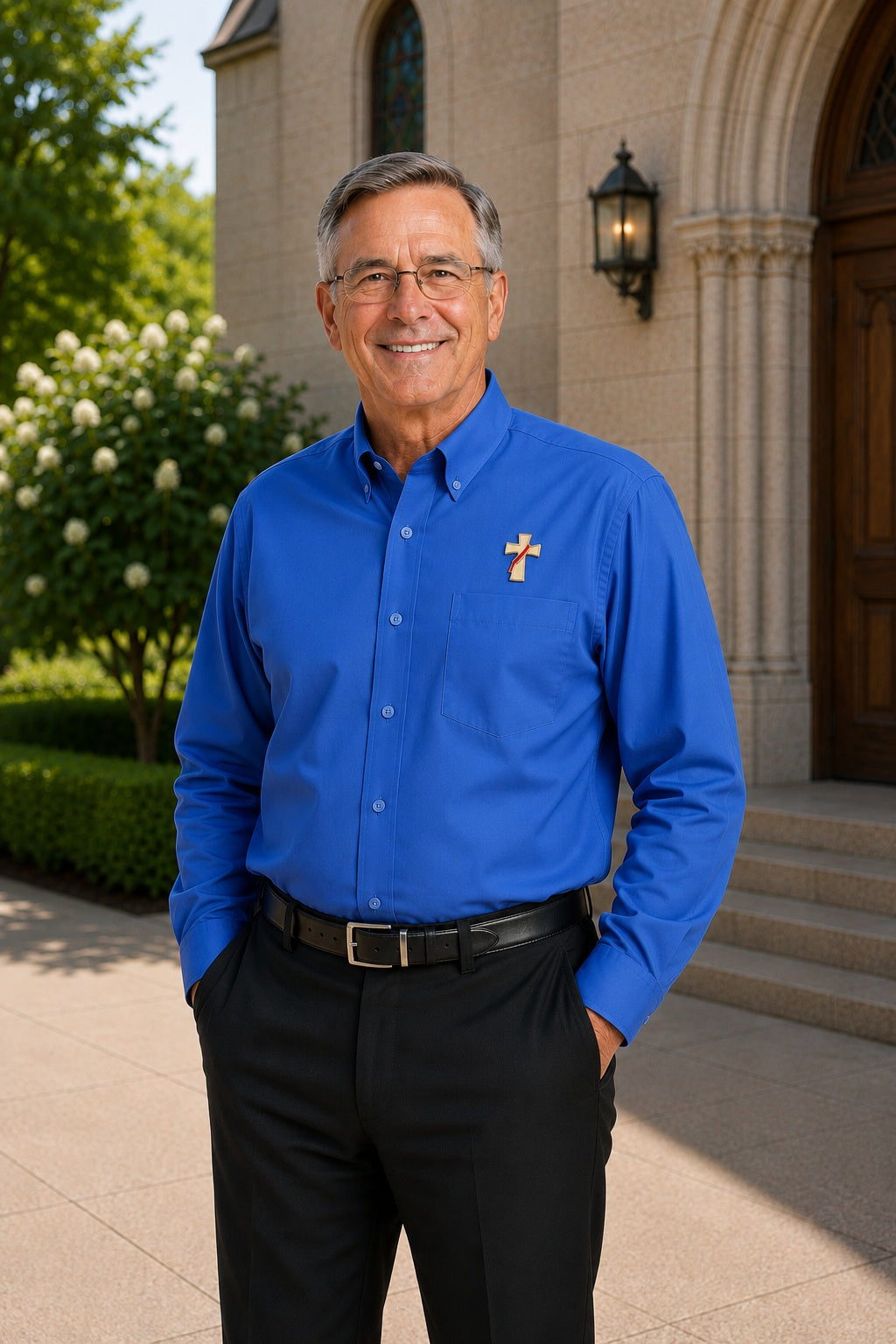 Deacon wearing a long sleeve ultramarine blue shirt with an embroidered symbol of a deacons cross on his left chest.