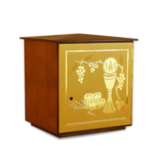 Single door tabernacle with chiseled image of a chalice, grapes, and ears of wheat sourrounded by a wood casing. Made in Italy and sold by The Clergy Store