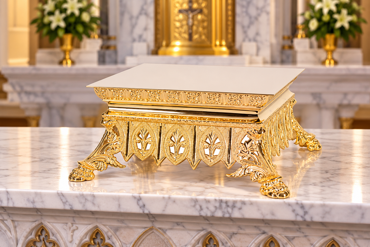 An ornate gold pedestal thabor with a square white marble top, featuring decorative carved legs and lion paw feet, set on a polished white marble surface.