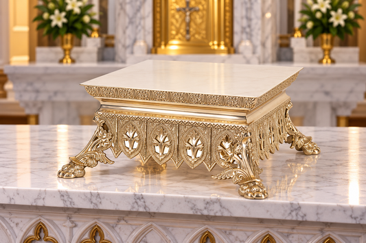 An ornate gold pedestal thabor with a square white marble top, featuring decorative carved legs and lion paw feet, set on a polished white marble surface.
