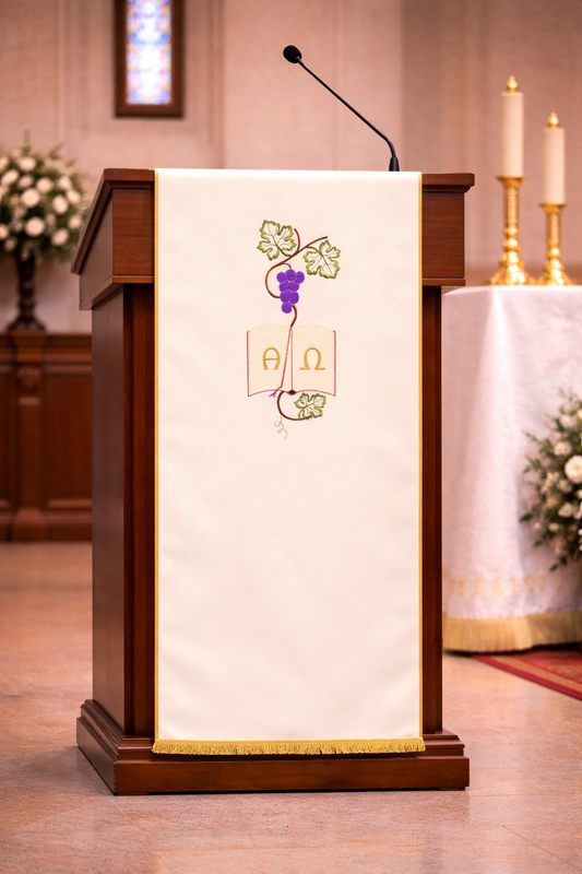 Ivory liturgical lectern cover with Alpha and Omega embroidery, grapevine design, and gold trim for church ambo or pulpit.