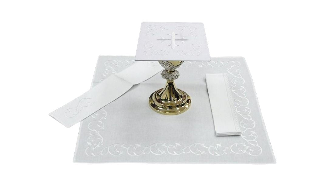 Mass linen set with embroidered cross and vines.