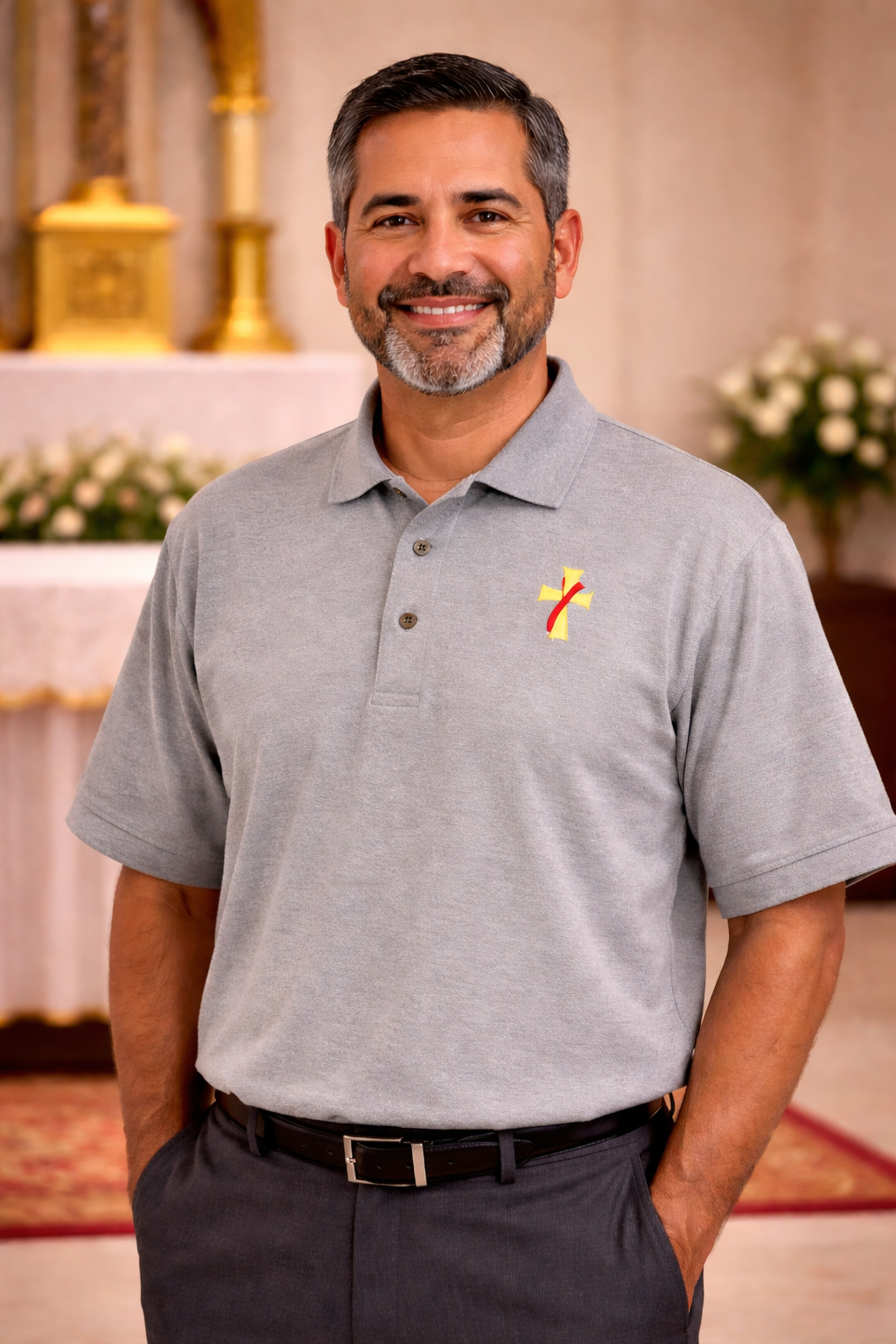 Man wearing a gray polo shirt with a deacon logo.