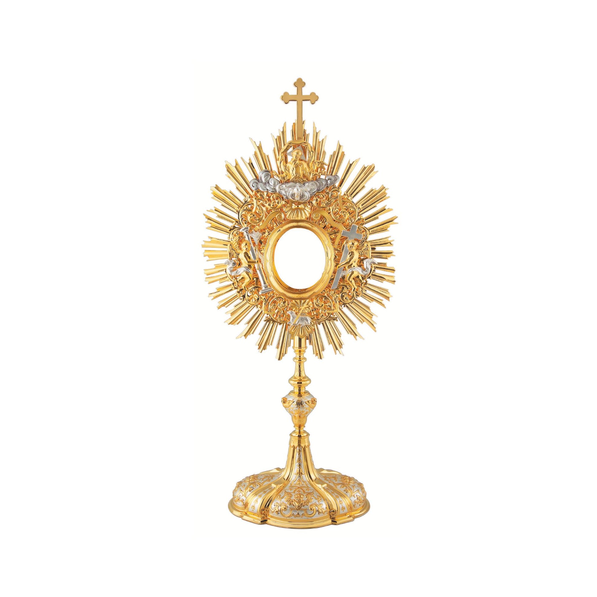 Baroque monstrance made of brass, 24-karat gold plated with silver plated accents. The glory consists of a sunburst topped with a cross and a decorative layer of floral ornaments around the luna case. God the Father and the Holy Spirit are placed at the top of the glory, while the Lamb of God is placed at the bottom. On either side of the luna case there is an angel figure. Both the node and the oval base richly adorned with floral ornaments and images of angels. The monstrance is coated with a protective l