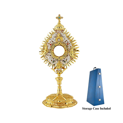 Richly adorned Baroque brass monstrance, 24-karat gold-plated with silver-plated accents. The glory consists of three layers: two sunbursts topped with a cross and a silver-plated wreath. The wreath features angel figures on either side of the luna case and God the Father sheltered with a canopy right above it. The luna case is surrounded by an ornamental design set with colorful stones. Highly decorated, sculpted node and base.