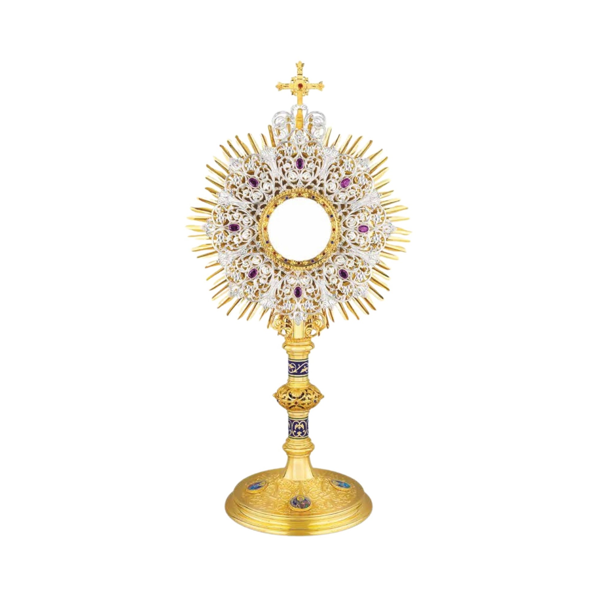 Highly decorated monstrance inspired by original German models from the late XIX and early XX centuries. Multilayered glory consists of a gold-plated sunburst and an elaborate silver-plated wreath with synthetic amethysts. The opening for the luna is surrounded with a round frame set with colorful stones. The monstrance is topped with a gold-plated cross. Both the node and the base are richly adorned with scrollwork patterns, colorful stones and enameled accents. Medallions on the base feature the Holy Fami