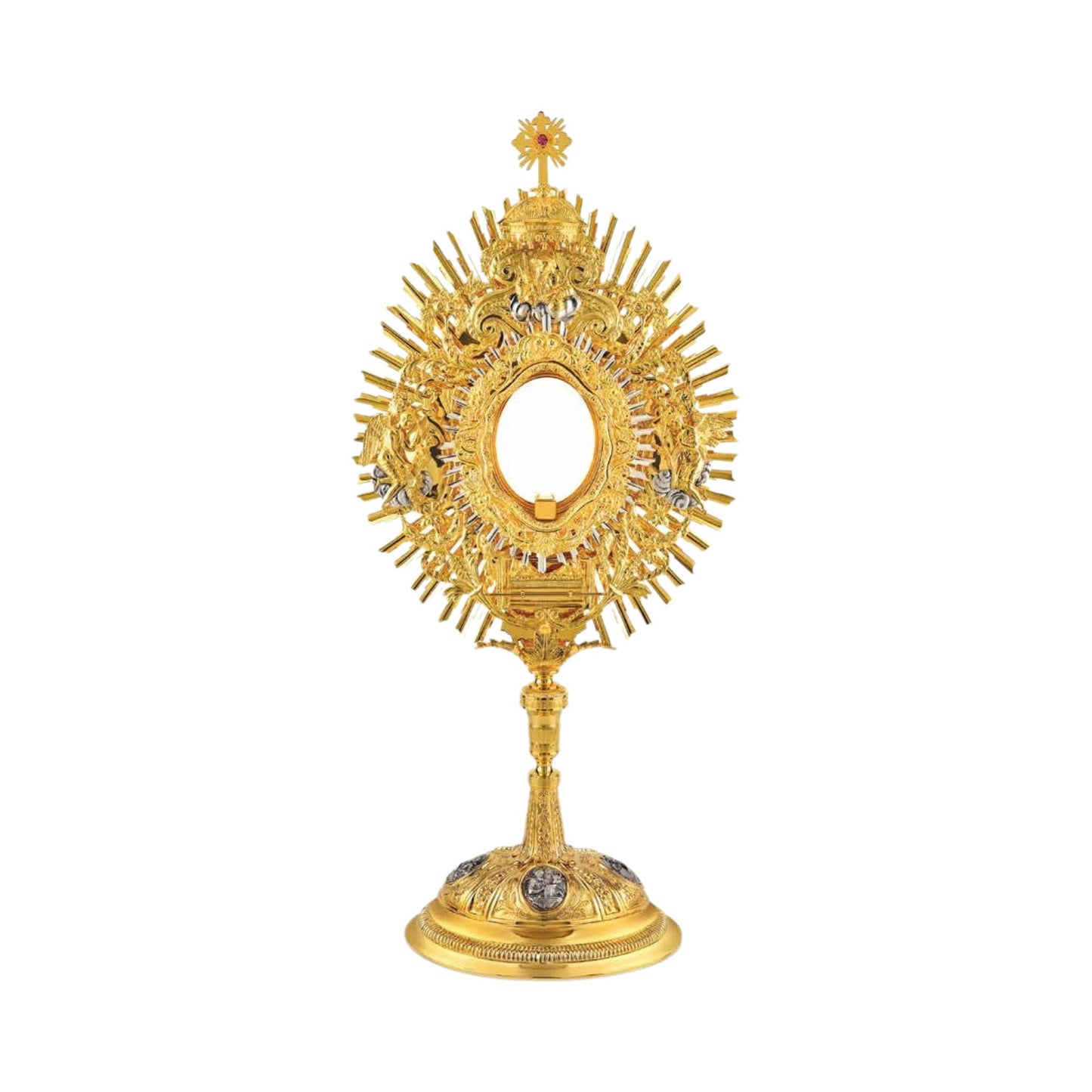 Brass monstrance, 24-karat gold-plated with silver-plated accents. The glory is embellished with an ornate wreath featuring grapevine and wheat motifs, and figures of God the Father, two angels and the Ark of The Covenant. The monstrance is topped with a dome and a cross encrusted with a pink stone. The oval base is decorated with silver-plated medallions of the Evangelists.